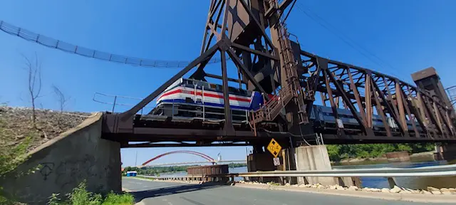 A train is crossing the bridge over the river.