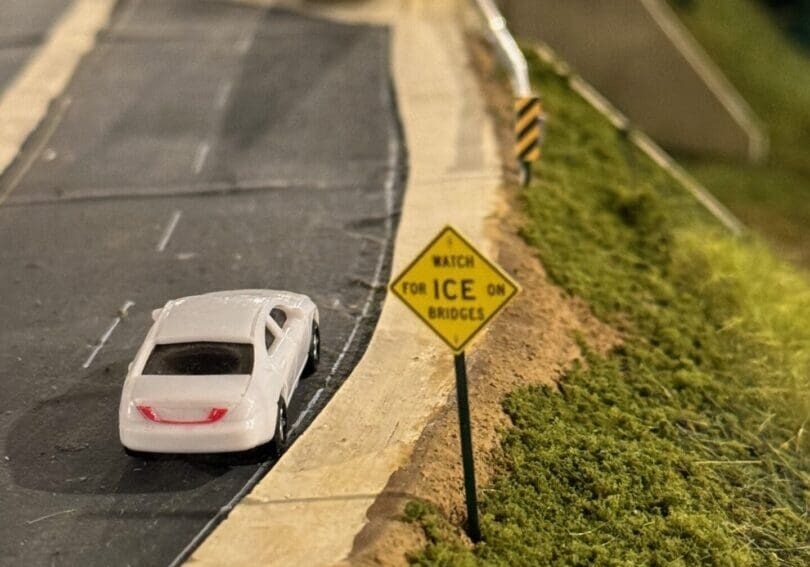 A car is driving down the road with no nice signs.